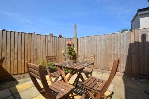 a wooden table and chairs with flowers on a fence at 2 Bed in Hunstanton oc-1778 in Hunstanton