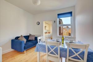 a living room with a table and a blue couch at 2 Bed in Hunstanton oc-1778 in Hunstanton