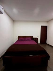 a bedroom with a bed with a purple blanket at Wayanad Cocos Villa in Tariyod