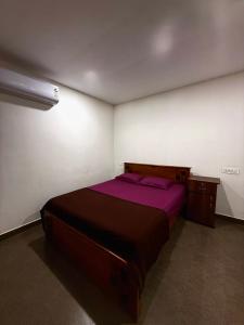 a bedroom with a bed with purple sheets and a desk at Wayanad Cocos Villa in Tariyod