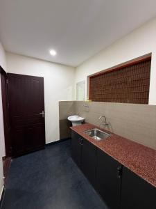 a bathroom with a sink and a toilet at Wayanad Cocos Villa in Tariyod