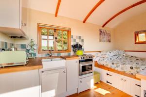 a kitchen with white cabinets and a bed in it at 1 Bed in Cove oc-cloudm in Bampton