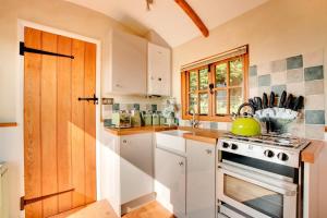 a kitchen with white cabinets and a stove at 1 Bed in Cove oc-cloudm in Bampton