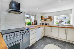 a kitchen with white cabinets and a stove at 2 Bed in Breage oc-jobcot in Breage