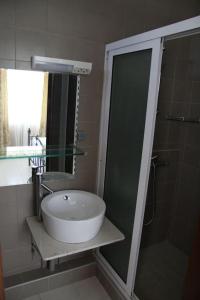 a bathroom with a sink and a glass shower at Les Trois Fleurs in Pointe aux Canonniers