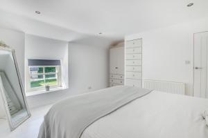 a white bedroom with a bed and a window at 2 Bed in Breage oc-jobcot in Breage