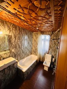 a bathroom with a tub and a sink and a toilet at Maharaja palace houseboat in Srinagar