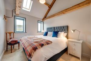 a bedroom with a large white bed with blue pillows at 7 Bed in Holme-on-Spalding-Moor oc-vy216 in Holme upon Spalding Moor