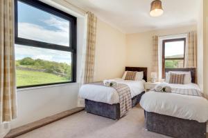 two beds in a room with a large window at 4 Bed in Hawes oc-ds940 in Hawes