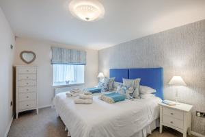 a bedroom with a large white bed with blue accents at 3 Bed in Bamburgh oc-gd0468 in Bamburgh
