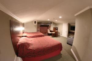 a hotel room with two beds and a fireplace at Santa Cruz Inn in Riverside
