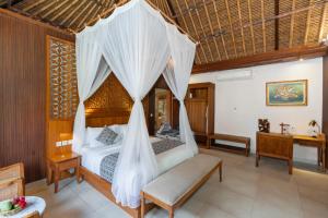 a bedroom with a bed with a mosquito net at Puri Andong Villa in Ubud +171 photos