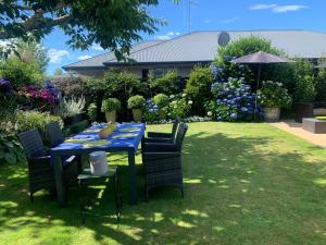 a blue table with chairs in a garden at Private Retreat in Cambridge