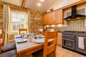 a kitchen with a wooden table and a stove at 3 Bed in Warkworth oc-nb400 in Warkworth