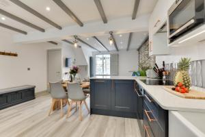 a kitchen with blue cabinets and a table with chairs at 2 Bed in Padstow oc-p00876 in Padstow