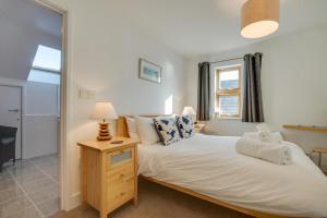 a bedroom with a bed and a lamp and a mirror at 2 Bed in Porthleven oc-quaysi in Porthleven
