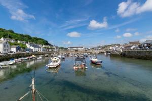 a group of boats are docked in a river at 2 Bed in Porthleven oc-quaysi in Porthleven