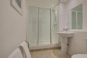 a white bathroom with a shower and a sink at 2 Bed in Porthleven oc-quaysi in Porthleven