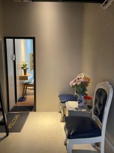 a room with two chairs and a table with flowers at Omeli homestay in Hanoi