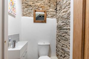 a bathroom with a white toilet and a stone wall at 3 Bed in Braunton oc-soufar in Braunton +17 photos