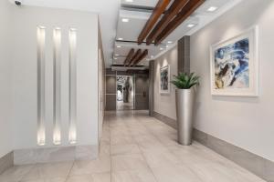 a hallway with white walls and a potted plant at Trilogy Surfers Paradise in Gold Coast