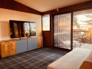 a room with a balcony with a bed and a television at The Fireside Inn in Idyllwild