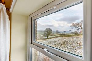 a window with a view of a field at 2 Bed in Burtersett oc-g28336 in Hawes