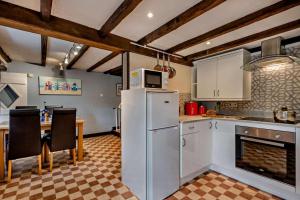 a kitchen with a refrigerator and a table with chairs at 3 Bed in Brancaster oc-p28395 in Brancaster +9 photos