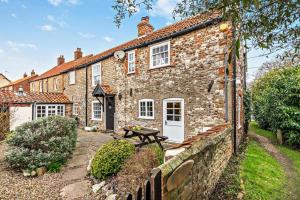 an old stone house with a picnic table in front of it at 3 Bed in Brancaster oc-p28395 in Brancaster