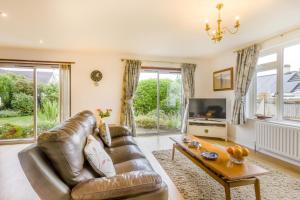 a living room with a leather couch and a table at 2 Bed in South Molton oc-willo in South Molton