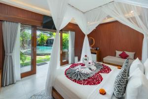 a bedroom with a bed with a white canopy at Puri Andong Villa in Ubud