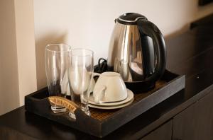 a tray with a tea kettle and glasses on a counter at Jackhill Hiriketiya in Dickwella