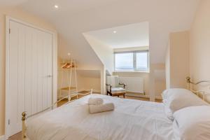 a bedroom with a white bed with a towel on it at 3 Bed in Aberdovey oc-v29263 in Aberdyfi