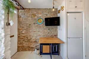 a kitchen with a table and a tv on a brick wall at 2 Bed in Looe oc-a29612 in Looe