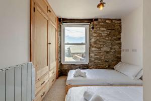 a bedroom with two beds and a window at 2 Bed in Looe oc-a29612 in Looe