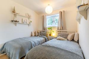 two twin beds in a room with a window at 2 Bed in Bodham oc-s29720 in Bodham