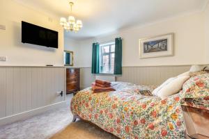 a bedroom with a bed and a tv on the wall at 2 Bed in Snettisham oc-t29559 in Snettisham