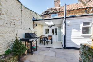 a patio with a grill and a table and chairs at 2 Bed in Snettisham oc-t29559 in Snettisham