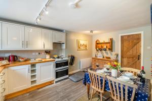 a kitchen with white cabinets and a table with chairs at 2 Bed in Hawes oc-b30521 in Hardraw