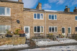 a brick house with a fence in front of it at 2 Bed in Hawes oc-b30521 in Hardraw