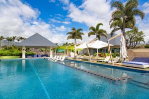 a pool at a resort with lounge chairs and palm trees at ❤PiH❤ Hale Kailani Heated Private Pool Spa in Waimea