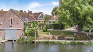 a house sitting on the water with a canal at 4 Bed in Wareham oc-r30563 in Wareham