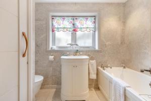 a bathroom with a sink and a tub and a window at 4 Bed in Wareham oc-r30563 in Wareham +41 photos