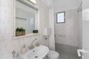 un baño blanco con inodoro y lavabo en Seample studios, en Chrissi Akti 44 fotos más