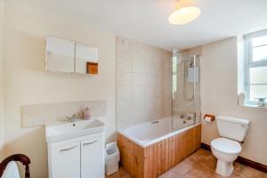 a bathroom with a toilet and a tub and a sink at 3 Bed in Carperby oc-e30625 in Carperby +20 photos
