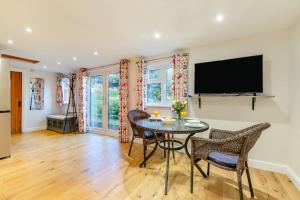 a dining room with a table and chairs and a flat screen tv at 1 Bed in Flimwell oc-s30131 in Ticehurst