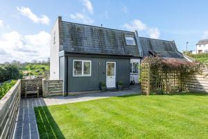 a green and white house with a yard at 3 Bed in Aberdovey oc-n29124 in Aberdyfi