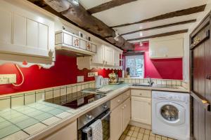 a kitchen with red walls and a washing machine at 1 Bed in Dulverton oc-l30886 in Dulverton +4 photos