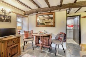 a living room with a table and chairs and a television at 1 Bed in Dulverton oc-l30886 in Dulverton