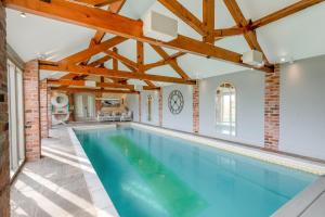 an indoor swimming pool with a brick wall and wooden ceiling at 5 Bed in Haceby oc-c31061 in Haceby